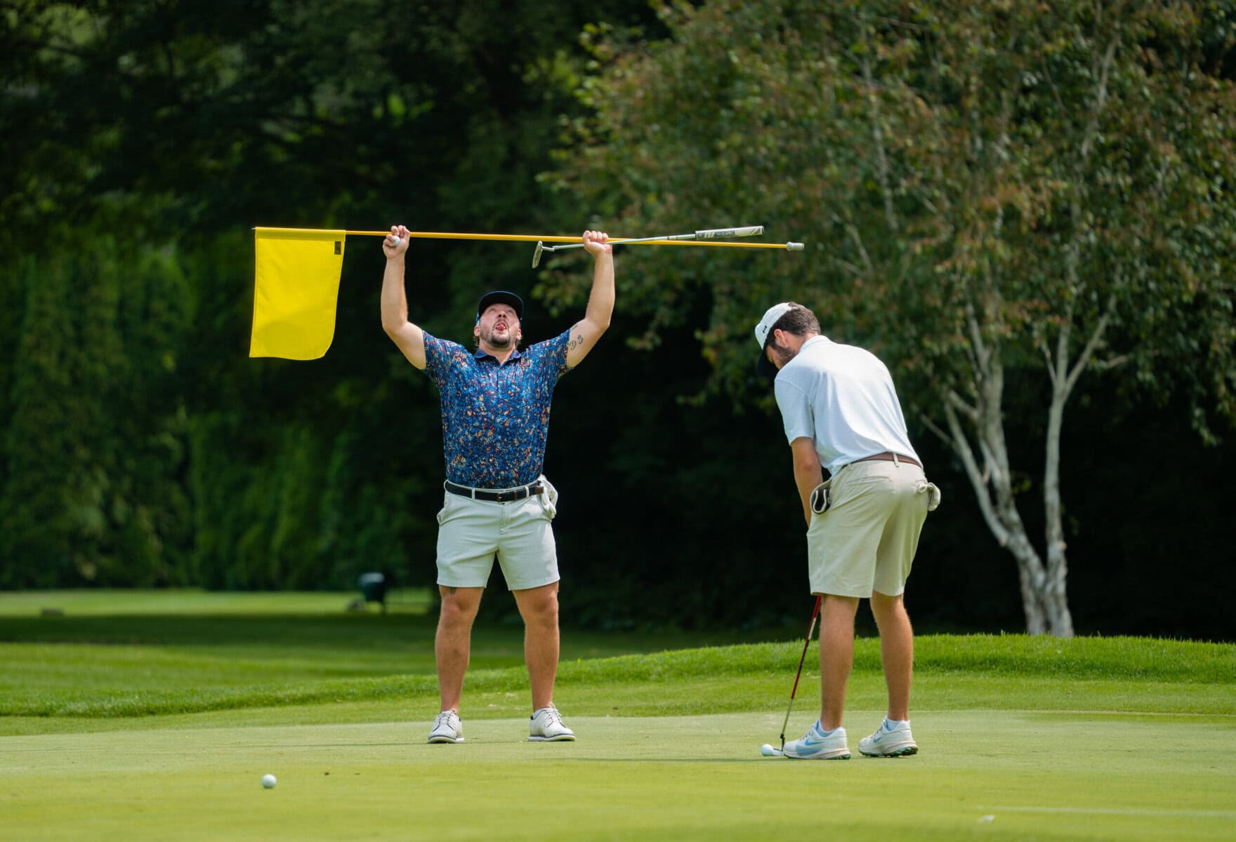 Quinton Spagnol clowns around with the pin while Michael Sanders putts.