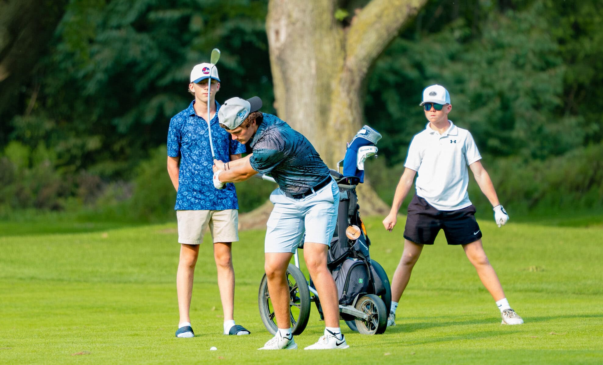 Spencer Tomczuk powers into a shot as Chase Hunter and Jayden Polgrabia look on.