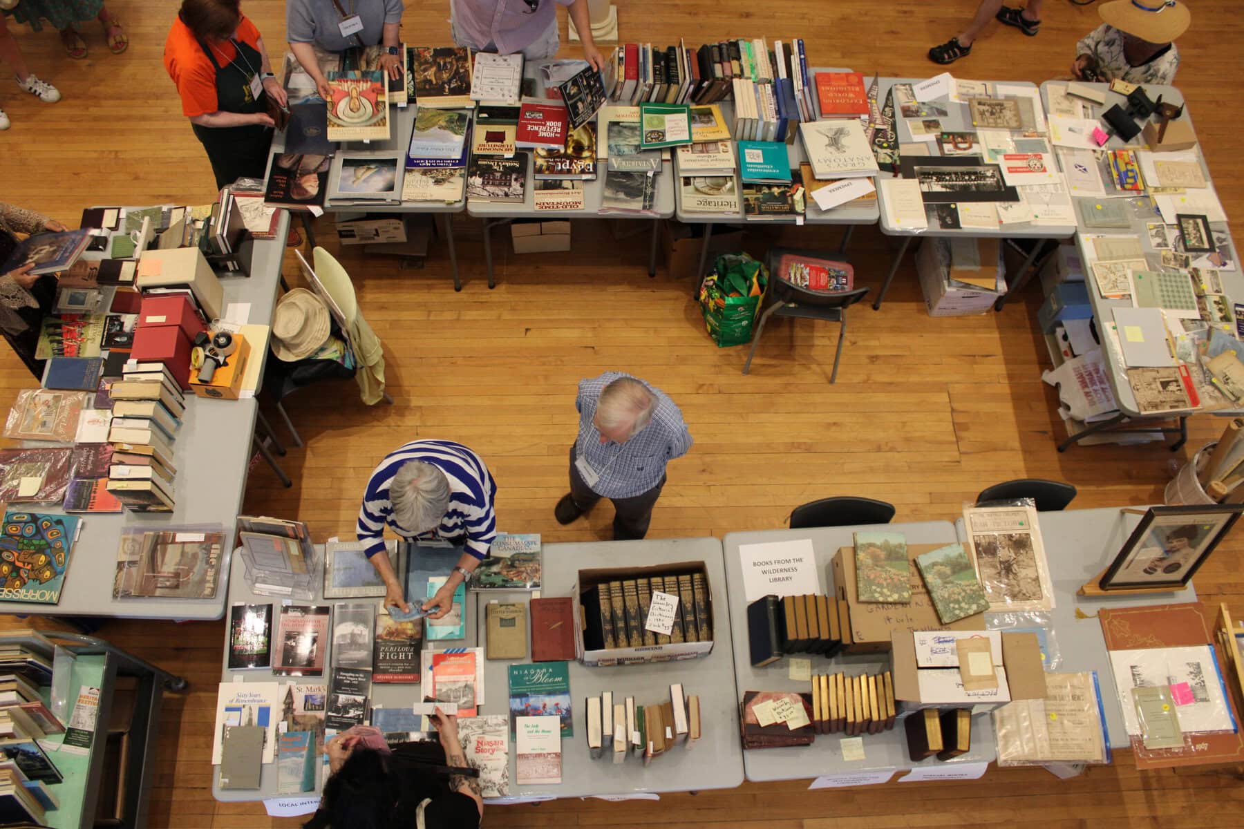 Visitors browse donated books and paper materials during a sale inside the Niagara-on-the-Lake Museum.