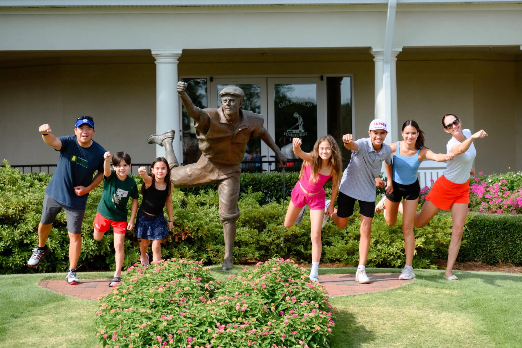 All five Perng kids are involved in sports. They're pictured here with the statue of Payne Stewart at Pinehurst Resort in North Carolina. From left:  dad Richard, Harrison, Margot, Coco, Eli, Winnie and mom Crystal. 