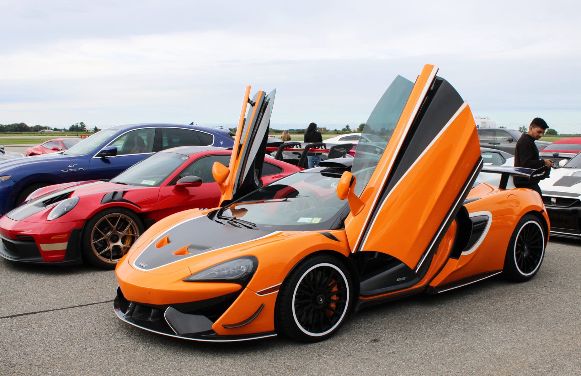 A McLaren 620R parks its doors skyward next to a Porsche 911 GT3 RS at the Niagara 5000 Hangar Experience, where more than 500 ticket holders spent Saturday afternoon among cars most of them will only ever see online. Sept. 19.
