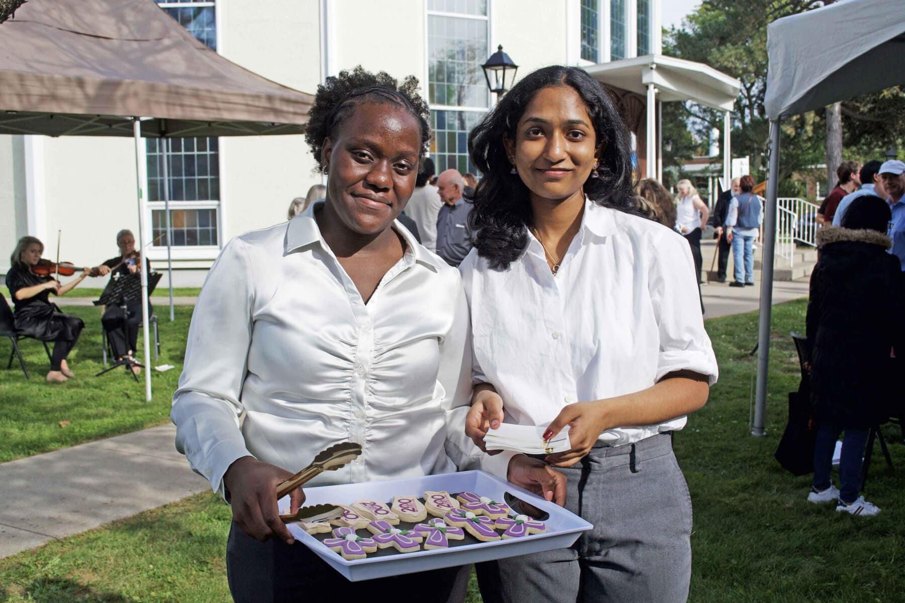 Grade 12 Holy Cross students Agnes Najjuuko and Neha Biju helped serve cookies and lemonade during the celebration. 