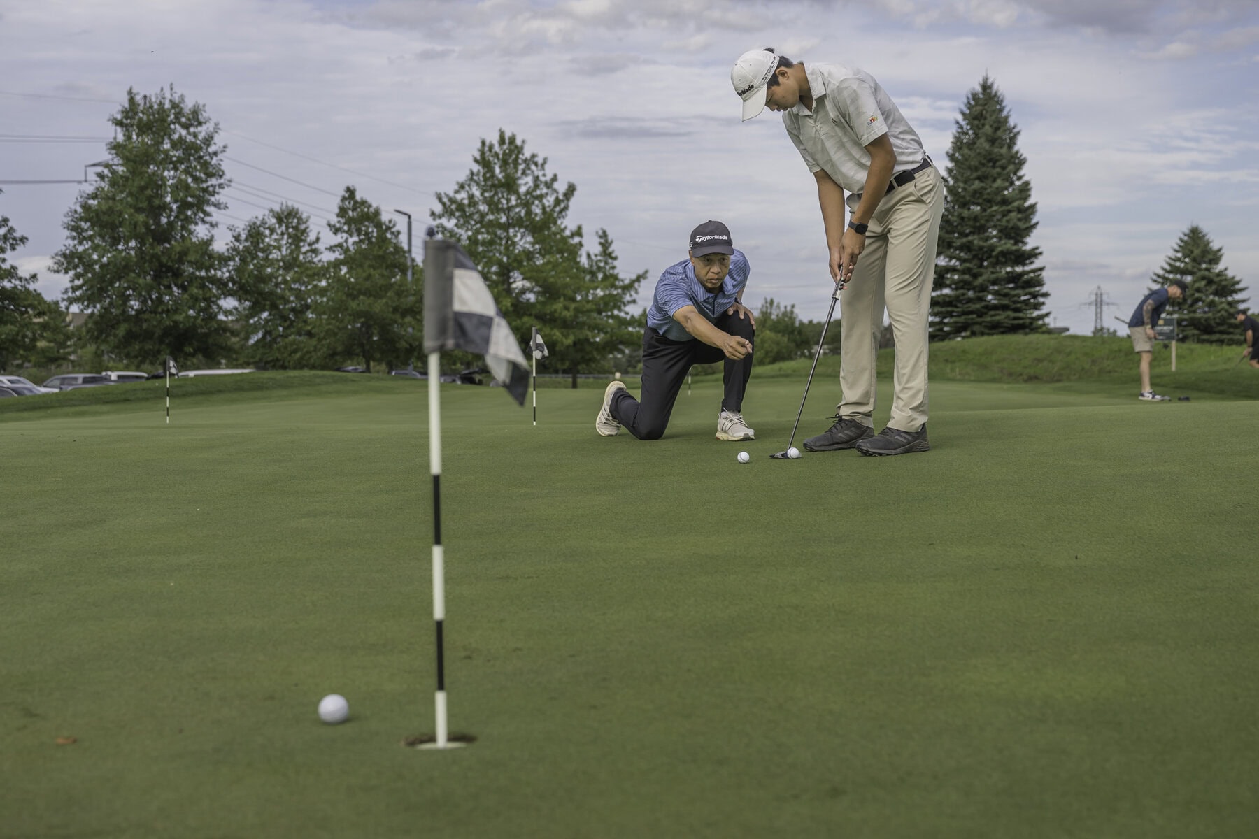 Dad Mike coaches Kaige Zhu on putting on the practice green at Royal Niagara Golf Club in Glendale. 