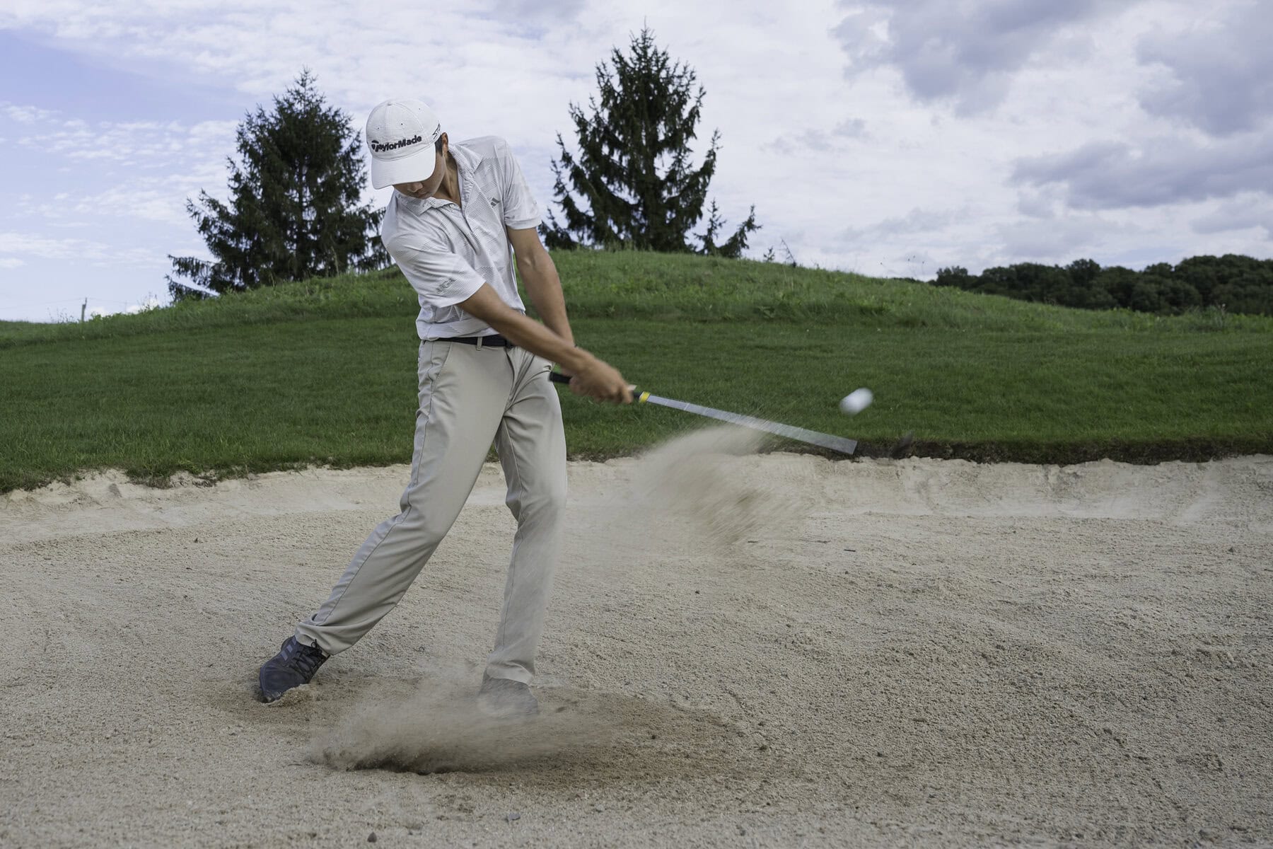 Kaige Zhu works on his bunker game. 