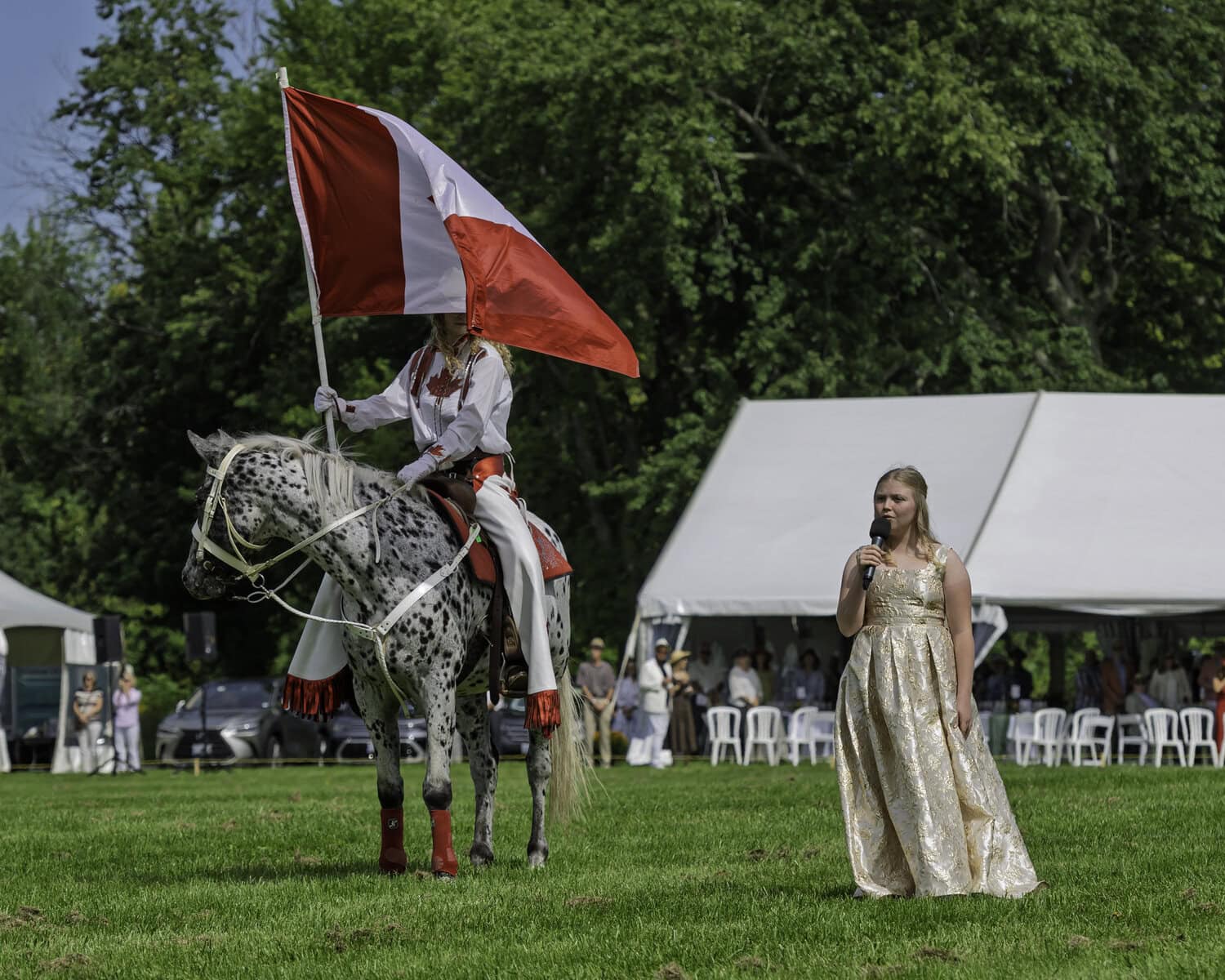 Kayla Fraser, from the local Yellow Door Theatre Project, helps open up the polo match with the Canadian national anthem, accompanied by a member of the Canadian Cowgirls waving the nation's flag.