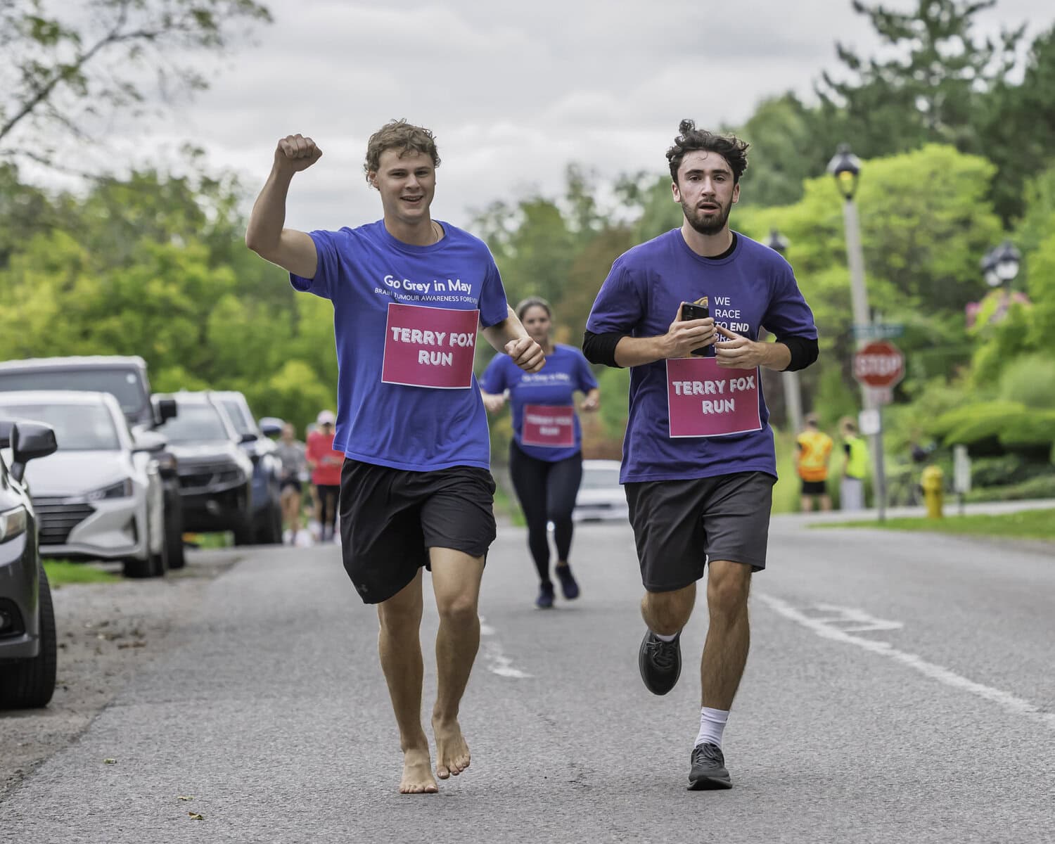 This pair of runners power through the final stretch of the run — one of them forgoing his kicks.