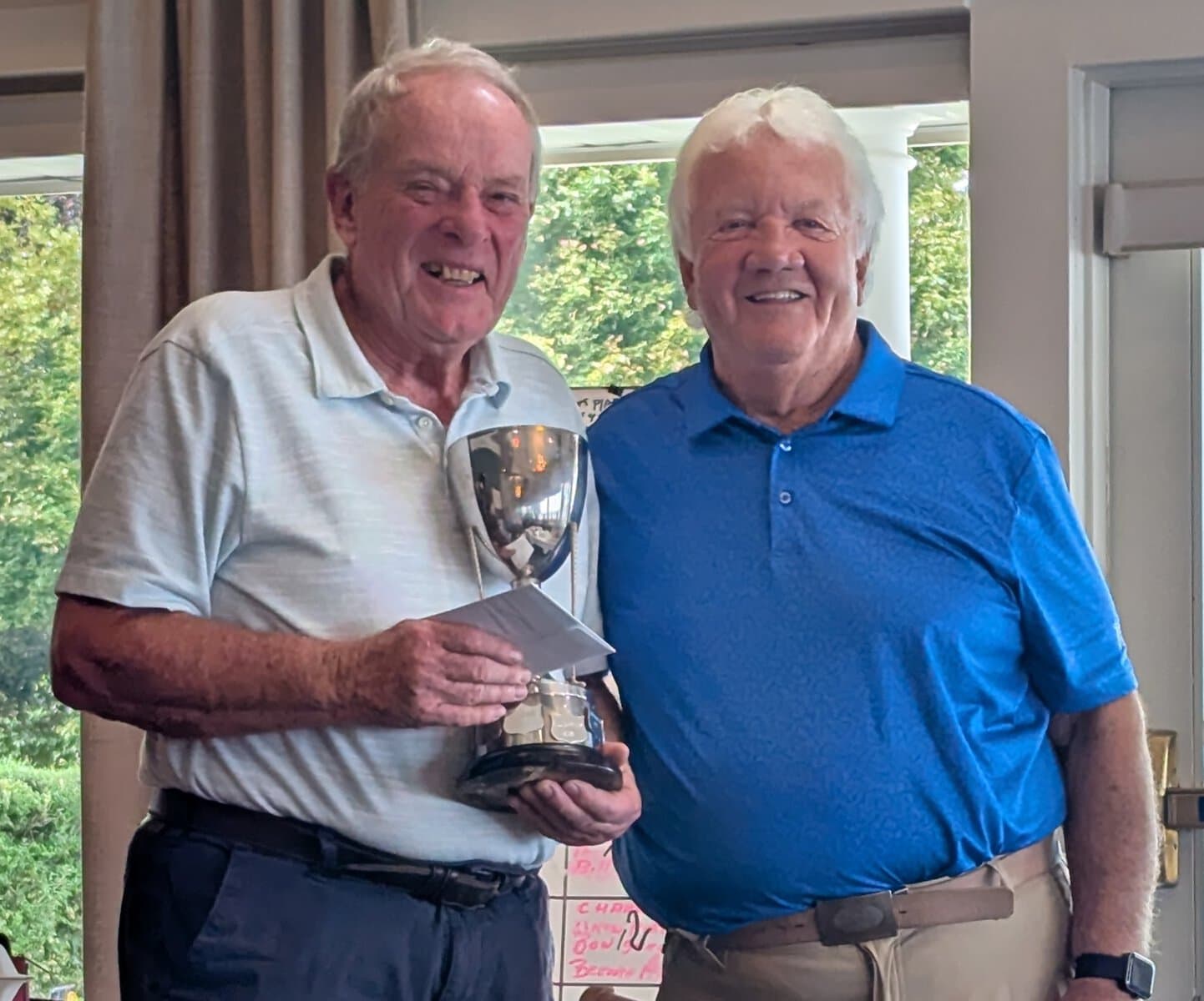 Doug Dineley receives the Golden Dog trophy from Woofs organizer Bill Katrynuk. 