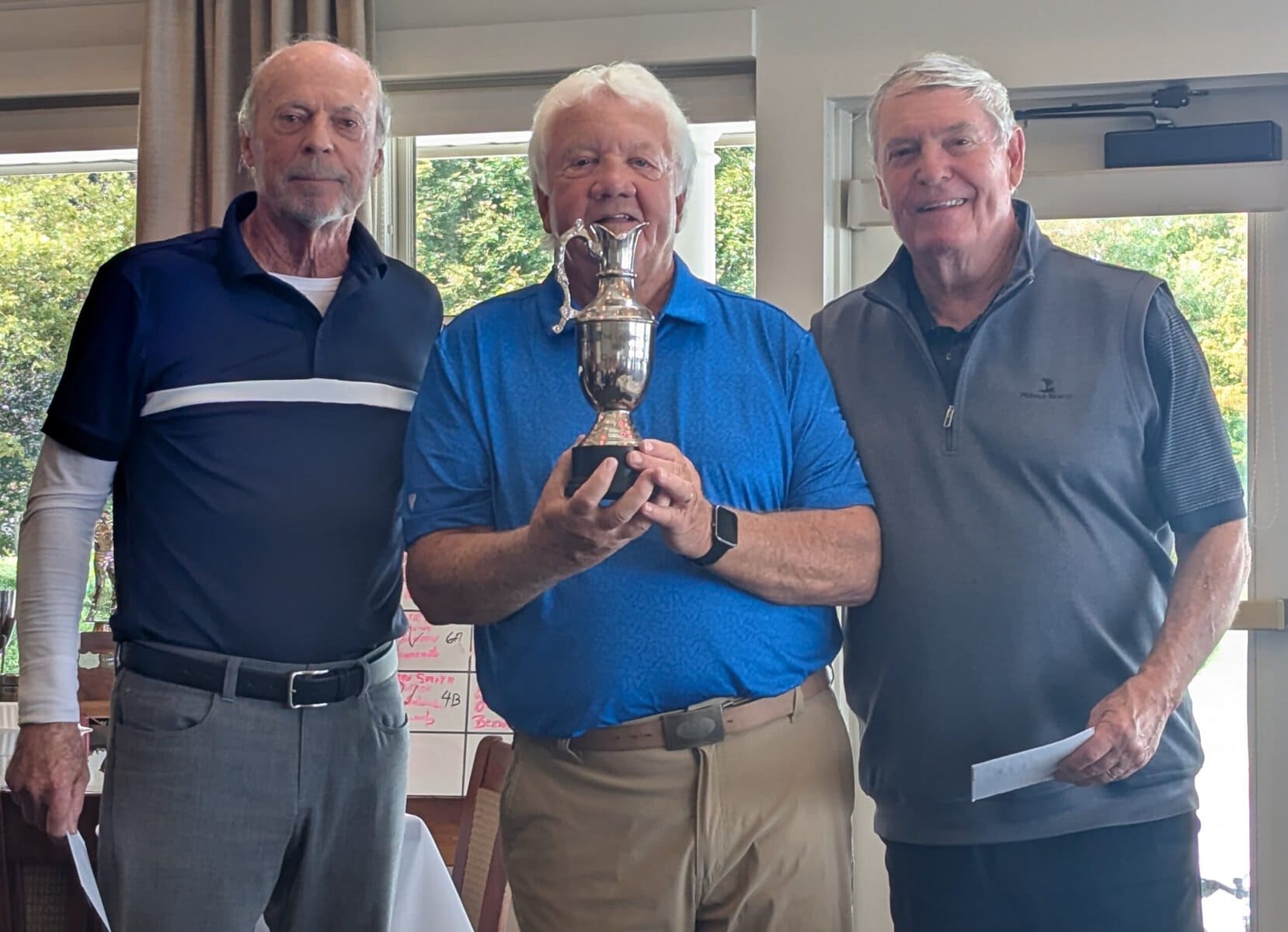 Legends Cup winners Mike Eagen, left, and Richard Sammons, right, with Woofs organizer Bill Katrynuk. 