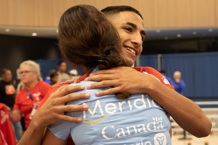 Zubin Gatta receives a hug after winning a bronze in the individual wrestling.