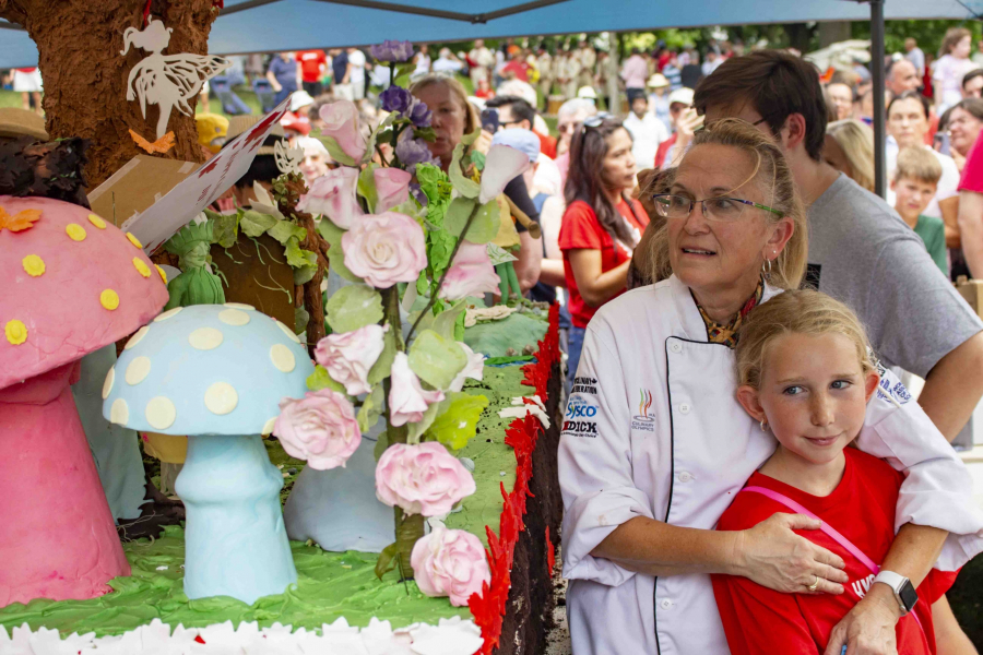 Catharine O'Donnell and her granddaughter Alyanna O'Donnell stand beside the Canada Day cake in Simcoe Park on July 1. Alyanna had a hand in helping design some of the little characters adorning the cake.