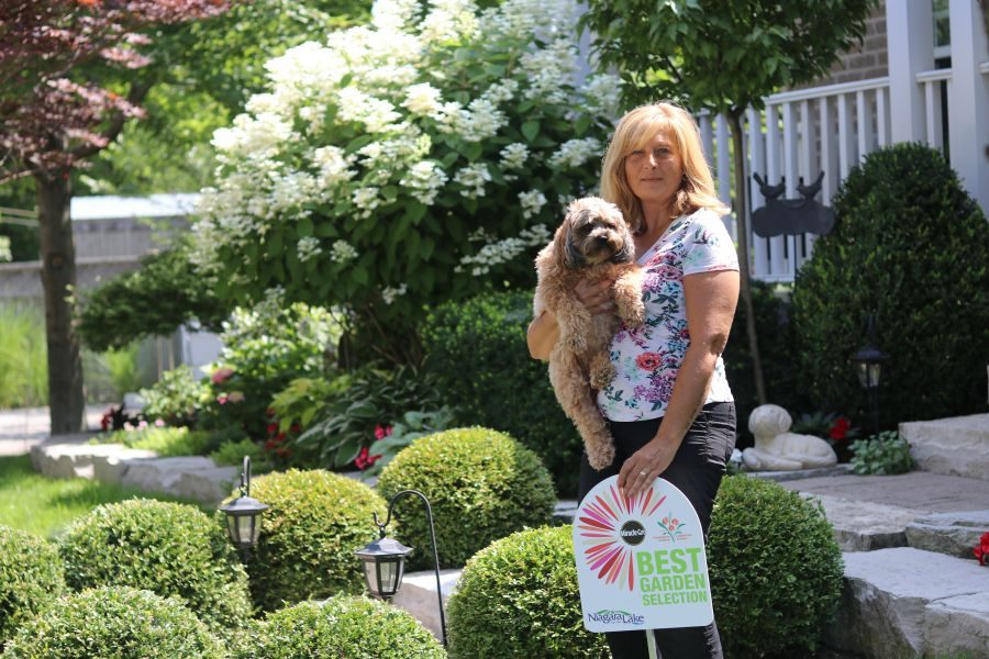 Diana_Ponte_with_Lexi_the_dog_in_her_award-winning_garden_on_Kirkwood_Drive._Dariya_Baiguzhiyeva_Cropped