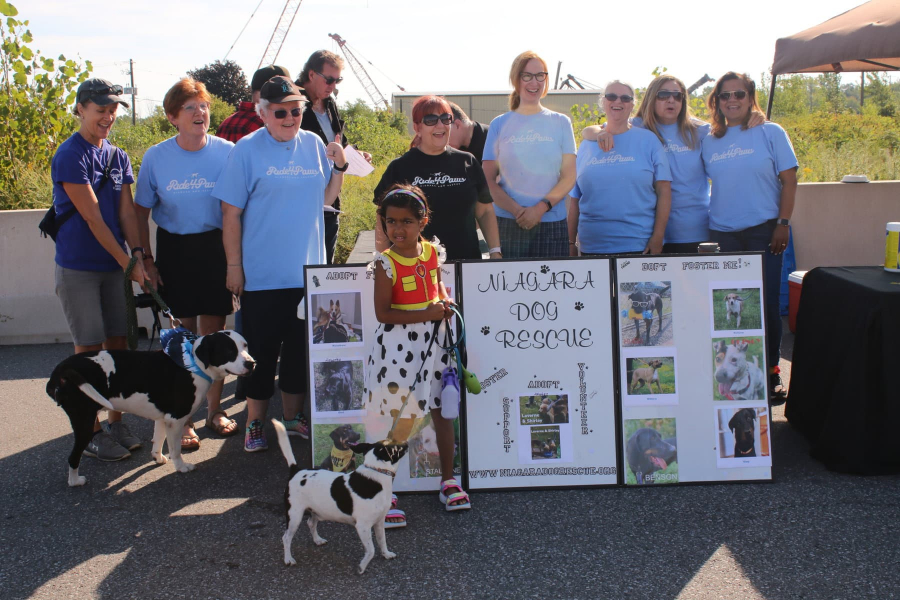 Ishani Ayona Pal, 6, with her dog spot, is flanked by Niagara Dog Rescue volunteers as she presents a $905 cheque to the organization on Saturday.
